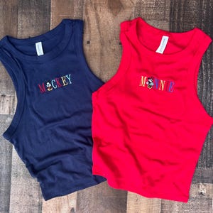 May include: A white ceramic mug with a black handle and the text "But first, coffee" in a handwritten style. The mug is on a white surface. The mug is likely for hot beverages.