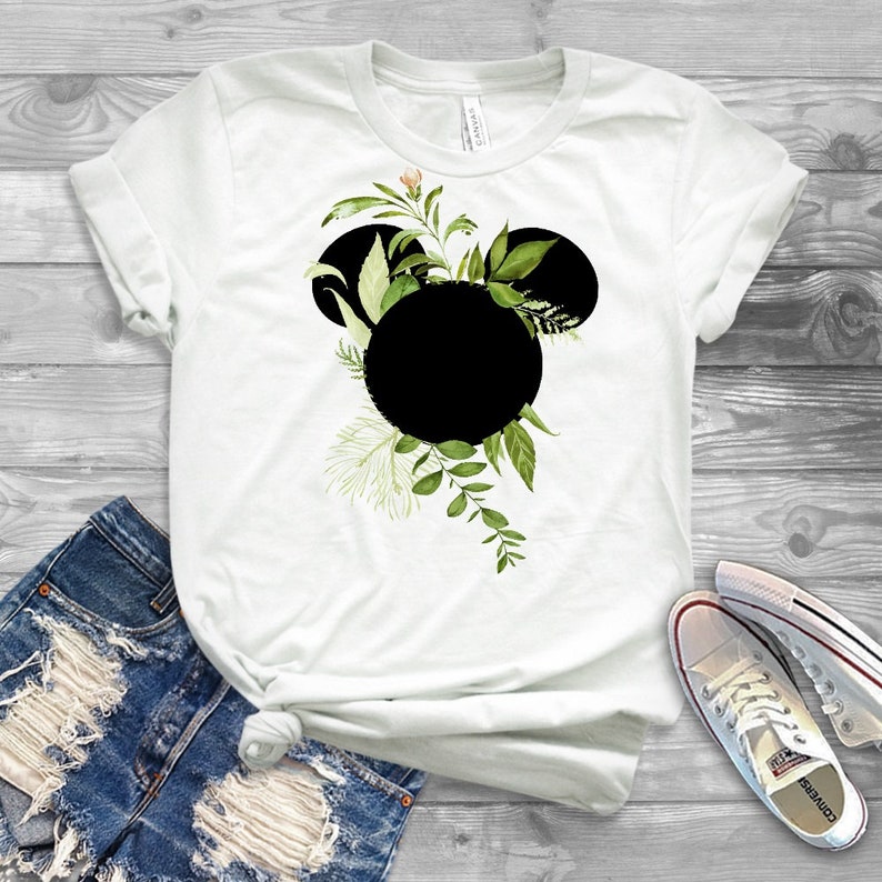 May include: White t-shirt with a black Mickey Mouse silhouette surrounded by green leaves and flowers.