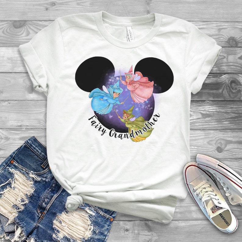 May include: White t-shirt with a black Mickey Mouse silhouette featuring three fairies inside. The text "Fairy Grandmother" is written below the silhouette.