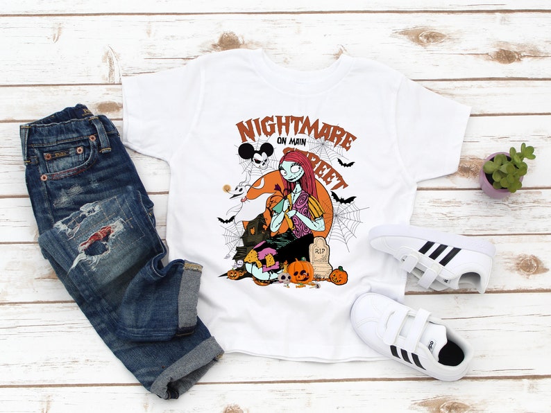 May include: White t-shirt with a graphic print of a character from the Nightmare Before Christmas movie. The text on the shirt says "Nightmare on Main Street".