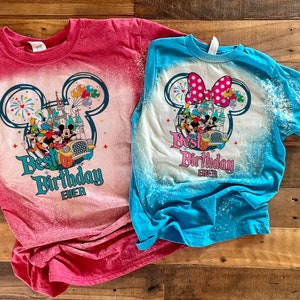 Puede incluir: Dos camisetas blanqueadas con un dise&ntilde;o de Mickey Mouse y el texto "Best Birthday Ever". La camiseta de la izquierda es roja y la camiseta de la derecha es azul.