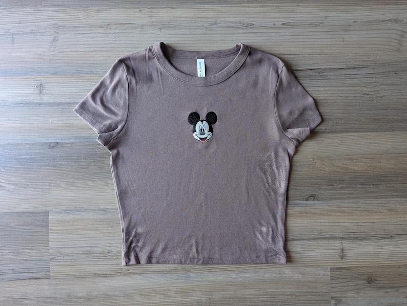 May include: A set of three ceramic mugs with a speckled, matte finish. The mugs are in shades of cream, light gray, and dark gray. Each mug has a simple, minimalist design and a rounded handle.