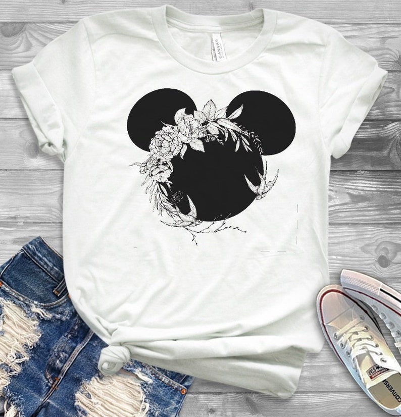 May include: White t-shirt with a black floral Mickey Mouse silhouette design.