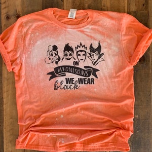 May include: Orange t-shirt with a bleach-splattered design. The shirt features a black graphic of four Disney villains with the text "On Wednesdays We Wear Black".