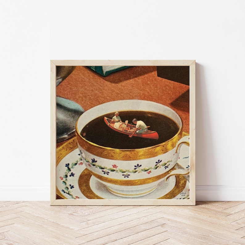 May include: A framed print of a surrealist image of a cup of coffee with a canoe and two people paddling in the coffee. The cup is white with gold and blue trim and is sitting on a saucer.