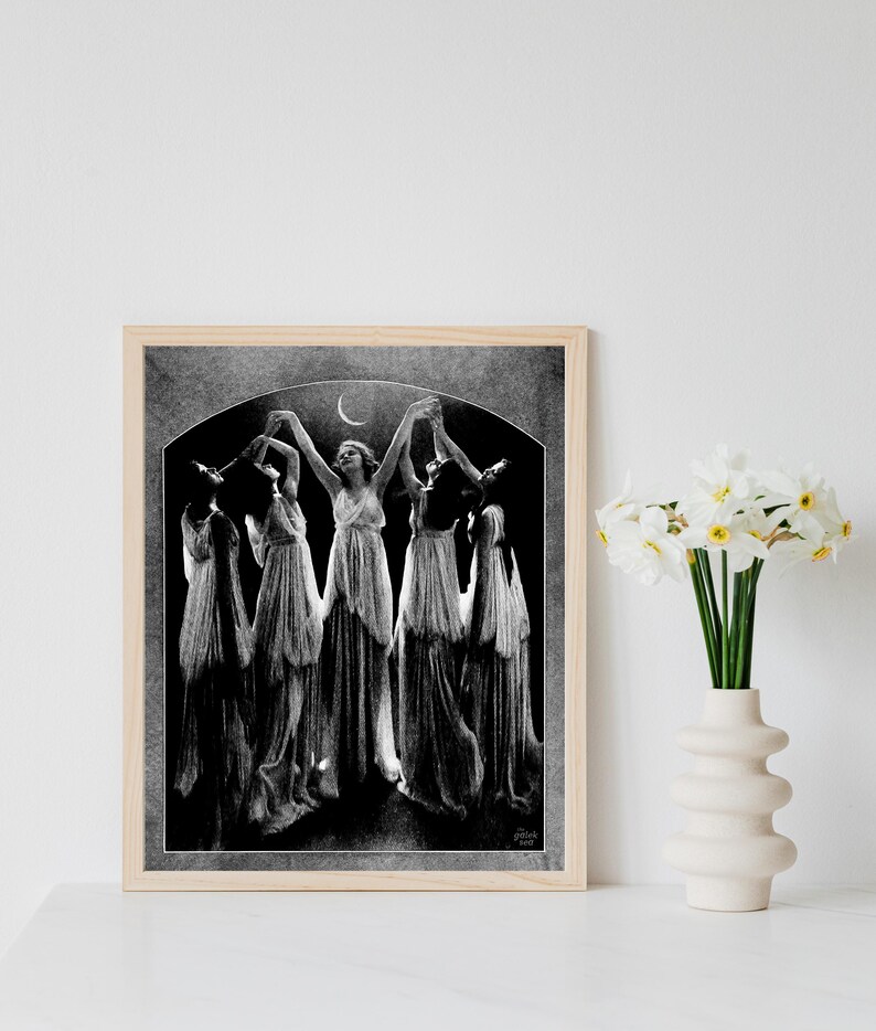 May include: Black and white photograph of five women in long dresses dancing under a crescent moon. The women are silhouetted against a dark background.