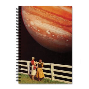 May include: Two women stand by a white picket fence, looking up at a large, orange and brown planet in the night sky.