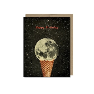 May include: A greeting card with a black background and white stars. The text "Happy Birthday" is printed in red. A full moon is depicted in a waffle cone, as if it were ice cream.