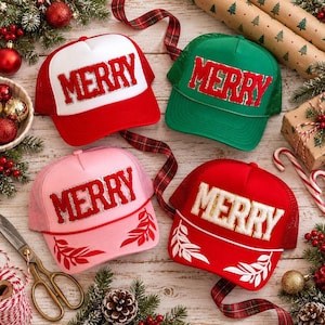 May include: Four trucker hats with mesh backs. The top left is red and white with red MERRY text. The top right is green with red MERRY text. The bottom left is pink with red MERRY text. The bottom right is red with white MERRY text.