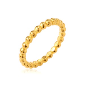 May include: A gold ring with a beaded design. The ring is made of small, round beads that are connected together to form a continuous band.