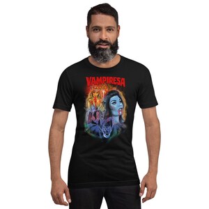 K&ouml;nnte beinhalten: Ein schwarzes T-Shirt mit einem grafischen Druck einer Frau mit roten Haaren und einer Frau mit blauen Haaren. Der Text "VAMPIRESA" ist in Rot auf dem Shirt gedruckt.
