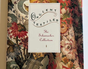 May include: A hardcover book titled Opulent Textiles: The Schumacher Collection by Richard E. Slavin III. The cover features a collage of floral and damask fabric patterns in shades of red, yellow, cream, and green with a central white label.