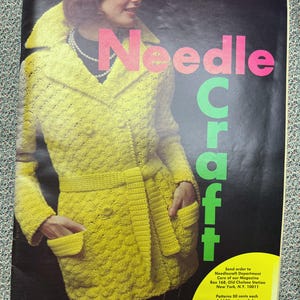 May include: A magazine cover featuring a woman wearing a yellow crocheted coat with a belt. The magazine is titled "Needle Craft" and includes instructions for ordering patterns.
