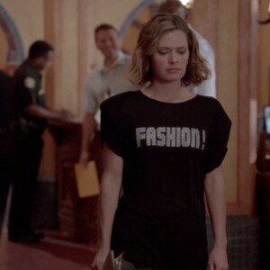 May include: A black short-sleeved t-shirt featuring the word FASHION! printed in large, bold, light-colored capital letters across the chest. The garment has a crew neckline and a relaxed fit with slightly dropped shoulder seams.