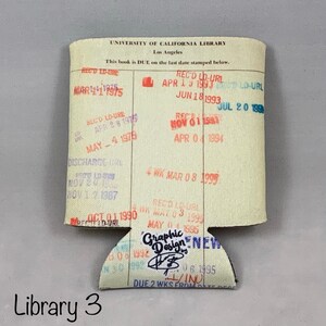 Puede incluir: Un aislante de bebidas de tela blanca con un sello de la Biblioteca de la Universidad de California y varios sellos de fecha. Los sellos son de tinta roja, azul y negra. El texto en el sello dice "University of California Library, Los Angeles. This book is DUE on the last date stamped below."