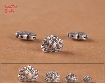 May include: Five silver lotus flower beads, each with a different size. The beads are intricately detailed and have a slightly aged finish.