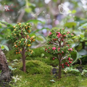 May include: Two miniature trees with green leaves and brown trunks. One tree has orange berries and the other has red berries. The trees are set on a bed of green moss.