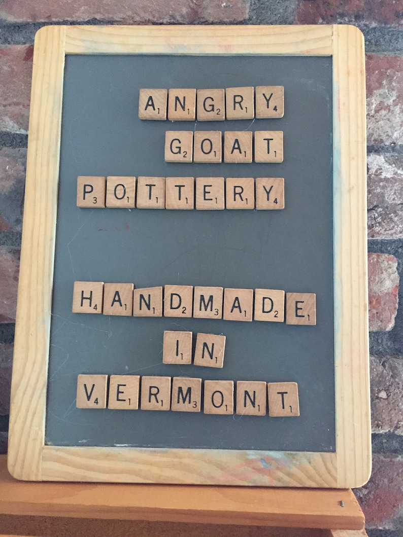 May include: A chalkboard with the words "Angry Goat Pottery Handmade in Vermont" spelled out using letter tiles.