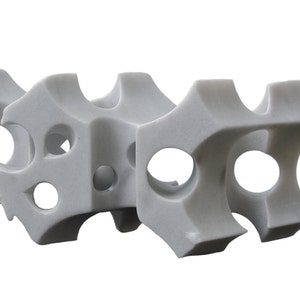 Puede incluir: Escultura de mármol blanco con un diseño geométrico que presenta múltiples agujeros interconectados. La escultura es de estilo abstracto y moderno.