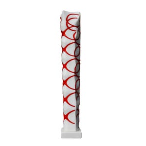 Puede incluir: Escultura de cerámica blanca con un patrón geométrico rojo. La escultura es alta y delgada, con una base cuadrada.