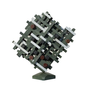 Puede incluir: Escultura abstracta hecha de formas geométricas verdes, blancas y negras. La escultura está montada sobre una base verde.