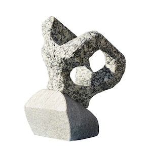 Puede incluir: Escultura abstracta hecha de granito gris y blanco. La escultura está compuesta por dos piezas, una encima de la otra. La pieza superior es una forma compleja con varios agujeros y aberturas. La pieza inferior es una forma simple y redondeada.