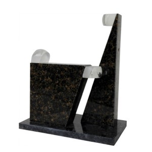 Pode incluir: Escultura abstrata feita de granito preto com três esferas de vidro transparentes. A escultura está sobre uma base retangular.