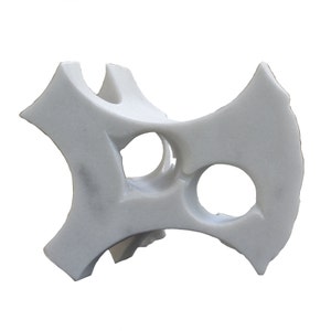 Puede incluir: Escultura abstracta de mármol blanco con varios agujeros y curvas.