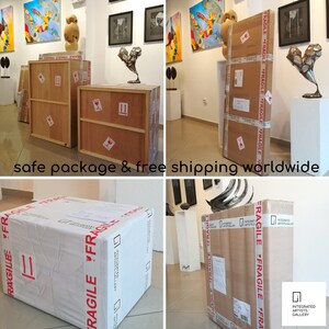 K&ouml;nnte beinhalten: Innenraum einer Kunstgalerie mit Holzkisten und Kartons, einige mit der Aufschrift "FRAGILE". Die Kartons sind mit Klebeband versiegelt und versandfertig. Kunstwerke werden an den W&auml;nden und auf Sockeln ausgestellt.