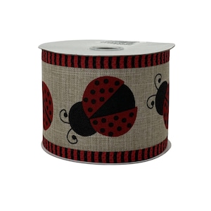 May include: A roll of decorative ribbon featuring a ladybug design. The ribbon has a tan background with red and black ladybug illustrations. The top and bottom edges have a red and black striped border.