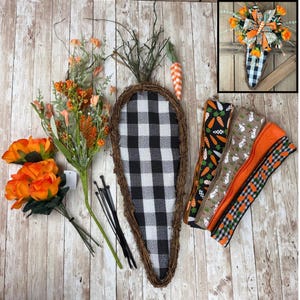 May include: A carrot-shaped decoration with a black and white checkered pattern, surrounded by a woven brown border. The decoration is accompanied by orange flowers, floral stems, zip ties, and decorative ribbons with carrot and bunny prints.