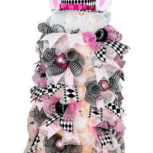 May include: A pink and black checkered bunny-themed tabletop tree with white mesh, pink and black ribbon, and white lights.