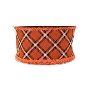 May include: A roll of decorative ribbon featuring a plaid pattern in orange, black, and white. The ribbon has a frayed edge and is suitable for crafts, gift wrapping, and seasonal decorations.