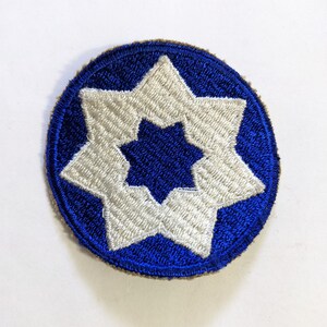 May include: A blue and white embroidered patch with a large white star in the center surrounded by eight smaller white stars.