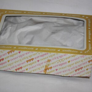 May include: A yellow and white cardboard box with a clear plastic window. The box is decorated with pink hearts and the text "EFFANBEE DOLLS THAT TOUCH YOUR HEART".