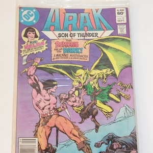 May include: A comic book cover featuring a green and yellow demon with wings, fighting a man with a sword. The comic book is titled "Arak, Son of Thunder" and the issue number is 13. The cover also features the text "The Demons from the Dark! A Macabre Masterwork by Roy Thomas & Alfredo Alcala."
