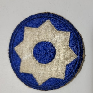 May include: A blue and white embroidered military patch with a seven-pointed star in the center.