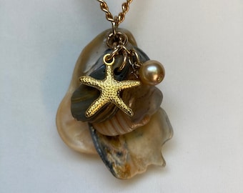 Sea shell pendant necklace, ocean shells clustered with a Pearl bead, a Gold plated Starfish and a piece of agate on a gold chain