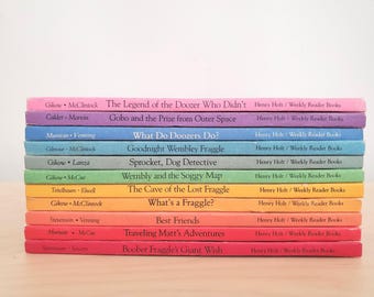 May include: A stack of colorful children's books with titles like "The Legend of the Doozer Who Didn't" and "Gobo and the Prize from Outer Space." The books are in various colors, including pink, purple, blue, and green.