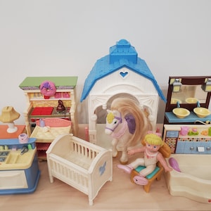 May include: A collection of colorful toy dollhouse furniture and accessories, including a kitchen set, crib, barn, and bathroom set. A toy horse and doll are also included. The toys are made of plastic and have bright colors.