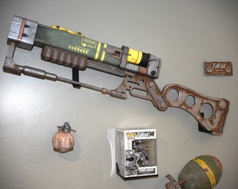 May include: A Fallout 4 themed display with a laser rifle, a mini nuke, a Power Armor Pop figure, and a Fallout 4 AER9 Laser Rifle sign.