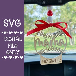 May include: A wooden baseball-shaped car charm with the word "mama" and the text "#12 STANLEY" hanging from a rearview mirror. The charm is decorated with a red ribbon and white and red beads.