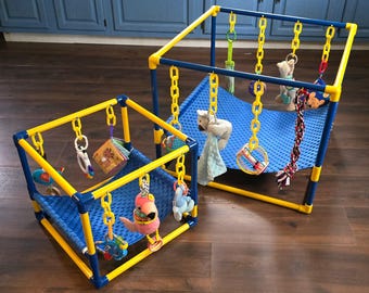 May include: Two baby play gyms with blue and yellow frames. Each gym has a blue fabric base and hanging toys, including plush animals and colorful rattles. The gyms are designed for infant play and development.