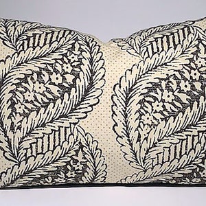 Puede incluir: Una almohada de color crema con un patrón paisley en blanco y negro. El patrón presenta detalles intrincados y un fondo punteado sutil.