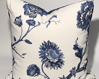 May include: White pillow with a blue floral pattern. The flowers are stylized and resemble sunflowers. The pillow is made of a soft, cotton fabric.