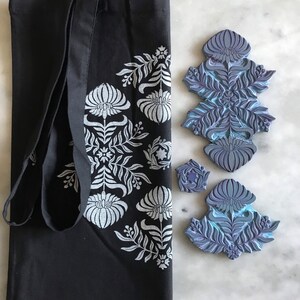 May include: A black tote bag with a white floral design. Three blue rubber stamps with floral designs are also shown.
