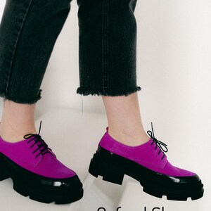 Pink suede Oxford shoes with black patent leather trim and chunky black soles