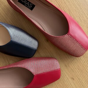 May include: Two pairs of red and silver striped flats. The flats have a square toe and a pink insole. The brand name "MIAS" is visible on the insole of one of the shoes.