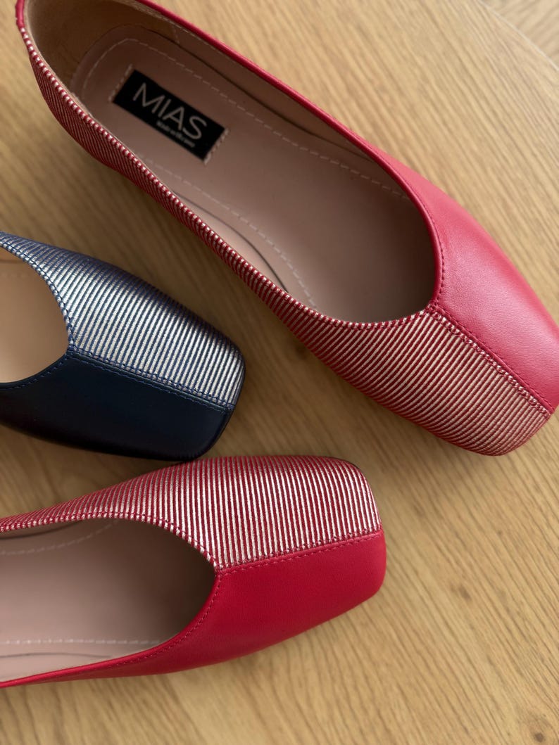 May include: Two pairs of red and silver striped flats. The flats have a square toe and a pink insole. The brand name "MIAS" is visible on the insole of one of the shoes.