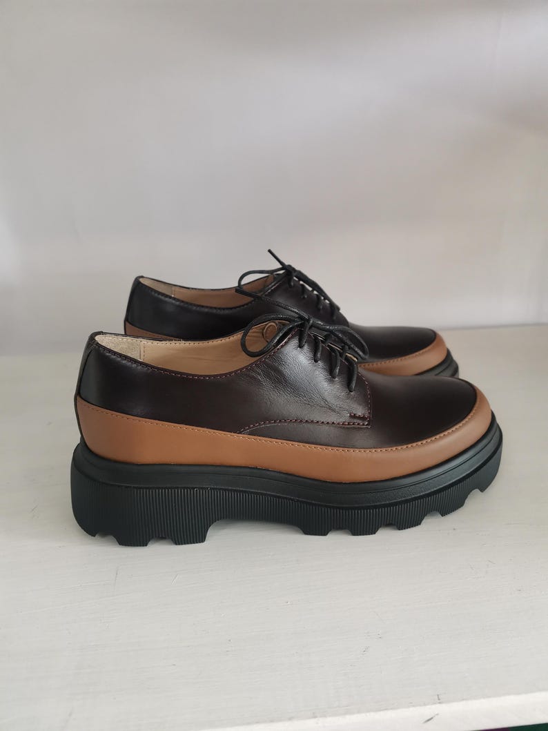 May include: Brown leather lace-up shoes with a chunky black platform sole.